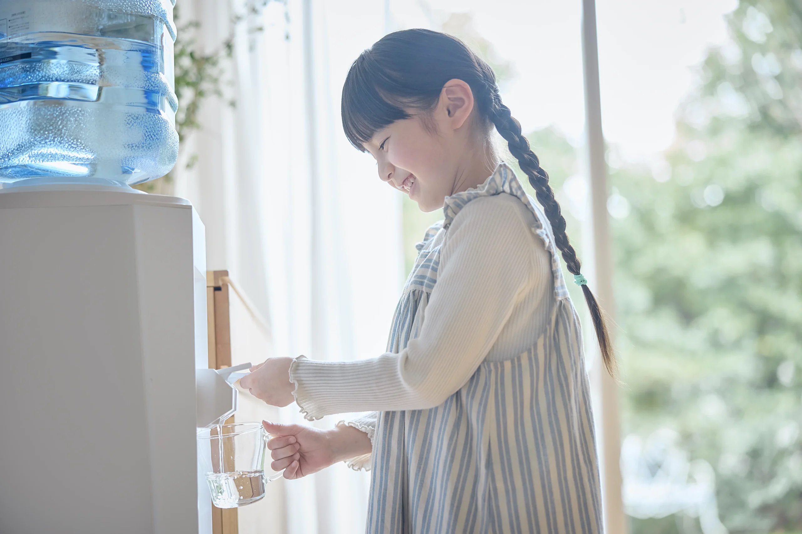 クリクラウォーターサーバーから水をくむ女の子